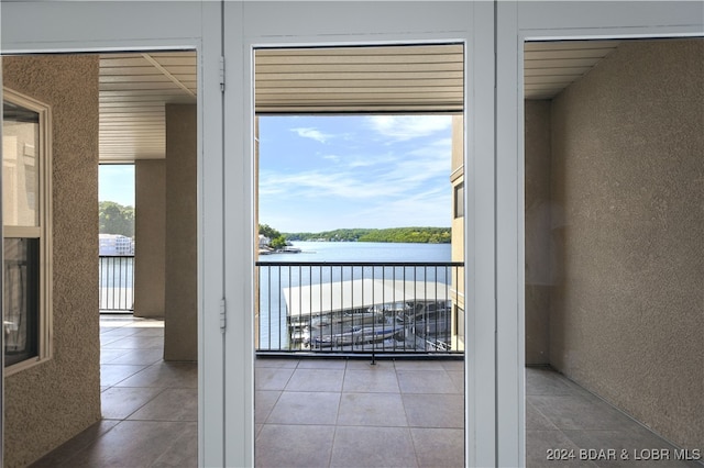 entryway featuring tile patterned flooring and a water view