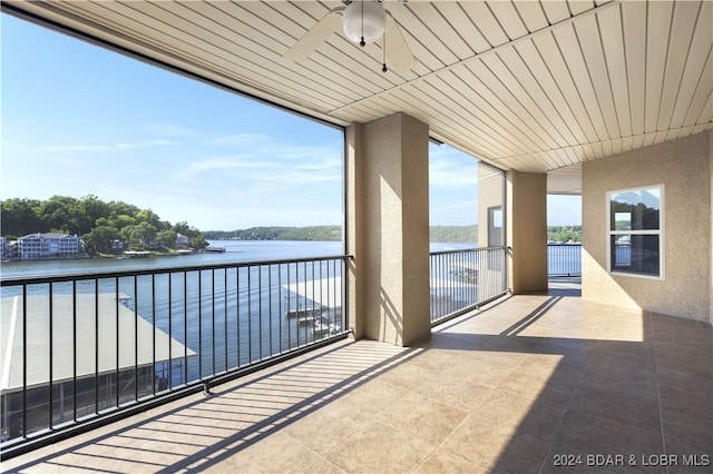 balcony with ceiling fan and a water view