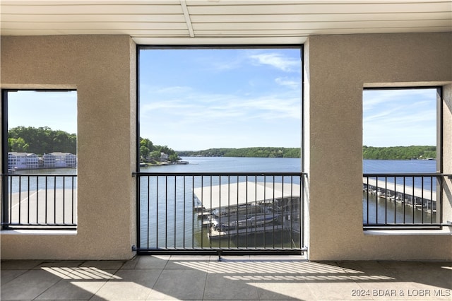 entryway featuring tile patterned floors, a healthy amount of sunlight, and a water view