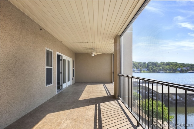 balcony featuring ceiling fan and a water view