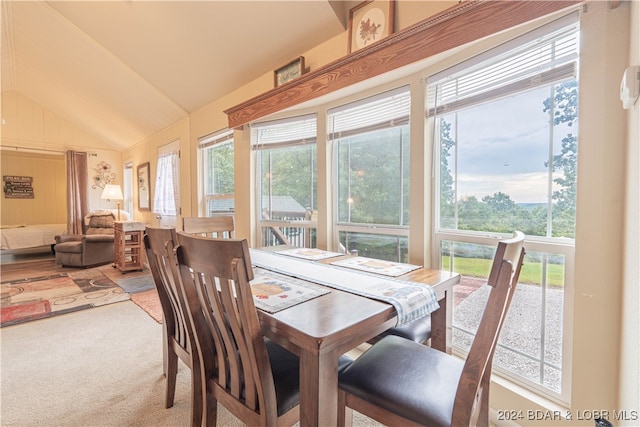 carpeted dining space featuring lofted ceiling