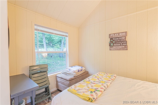 bedroom featuring vaulted ceiling, wood-type flooring, and multiple windows