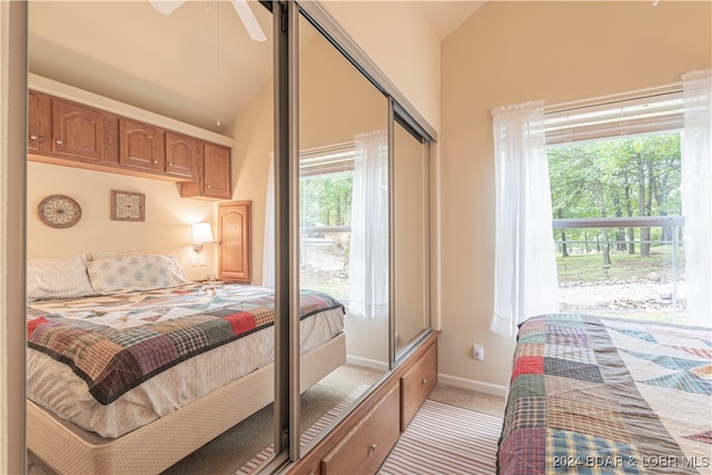 carpeted bedroom featuring ceiling fan, high vaulted ceiling, and a closet