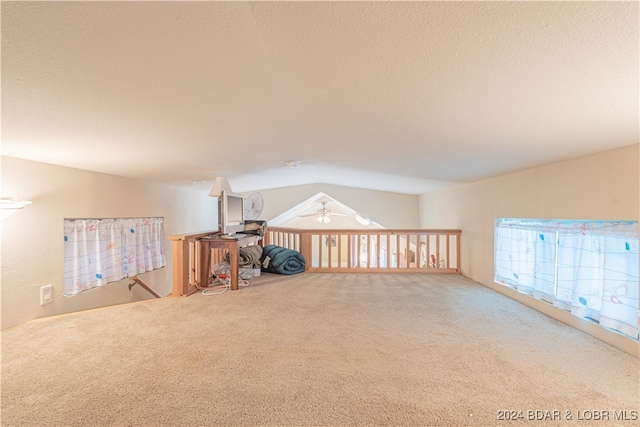 interior space with carpet floors, ceiling fan, and lofted ceiling