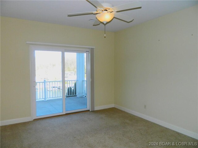 carpeted spare room featuring ceiling fan