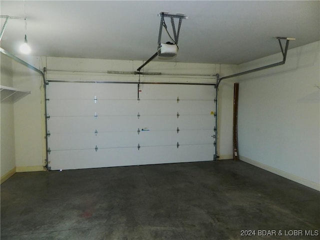 garage with baseboards and a garage door opener