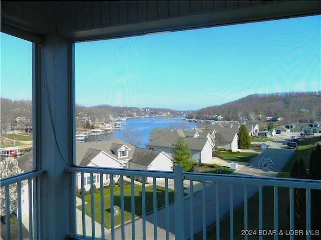 balcony featuring a water view and a residential view