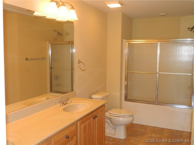 full bath with shower / bath combination with glass door, tile patterned flooring, a sink, and toilet