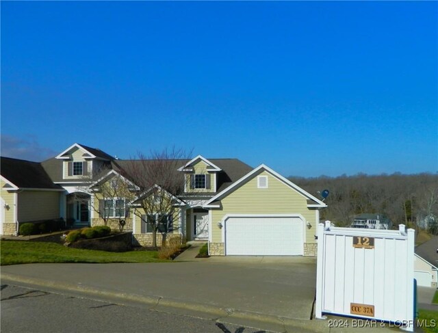 view of front of property with stone siding and concrete driveway