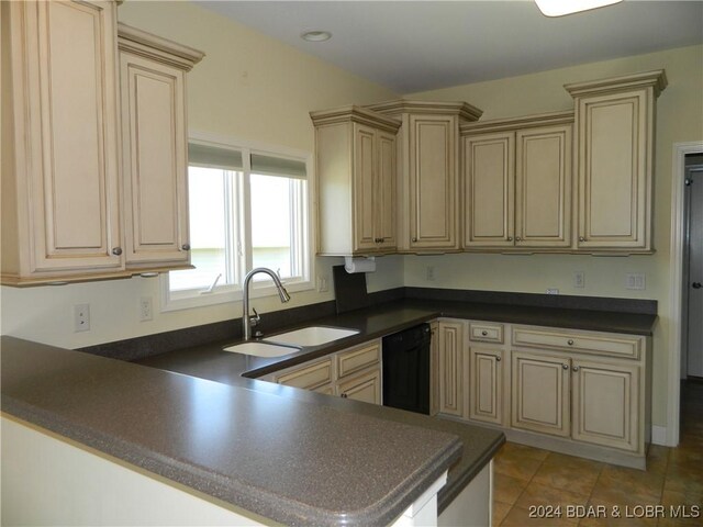 kitchen with dishwasher, sink, cream cabinets, light tile patterned floors, and kitchen peninsula