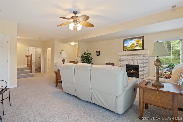 carpeted living room with ceiling fan and a brick fireplace