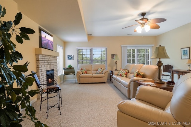 living room featuring light carpet, a brick fireplace, and ceiling fan