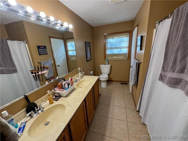 bathroom with toilet, vanity, tile patterned flooring, and a textured ceiling