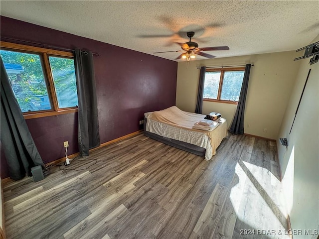 unfurnished bedroom with ceiling fan, hardwood / wood-style floors, and a textured ceiling