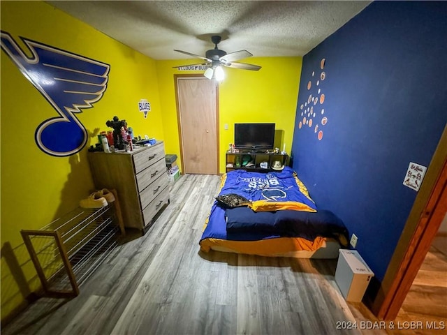 bedroom featuring ceiling fan, a textured ceiling, and hardwood / wood-style flooring