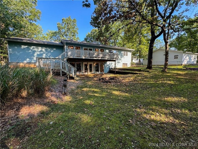 back of house featuring a deck and a yard