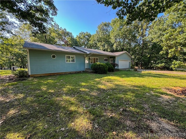 view of front of house with a garage and a front lawn