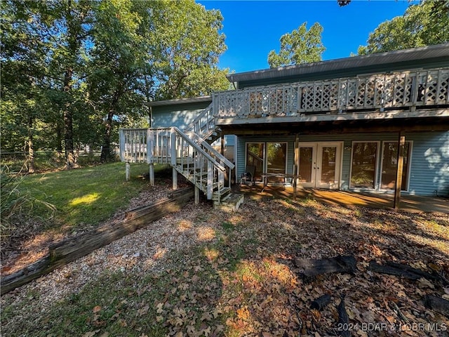 back of house featuring a deck and a lawn