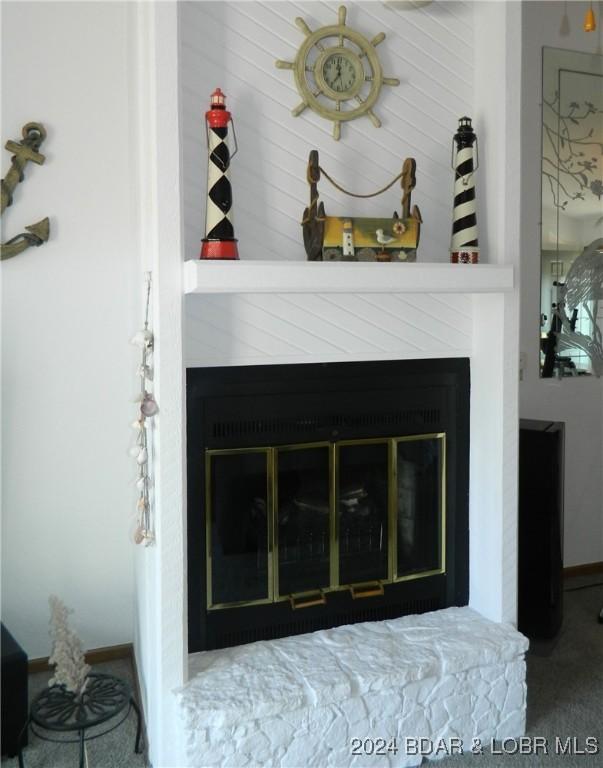 interior details with a glass covered fireplace