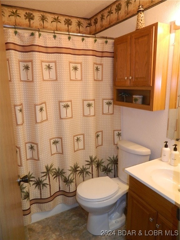 bathroom featuring tile patterned flooring, toilet, and vanity