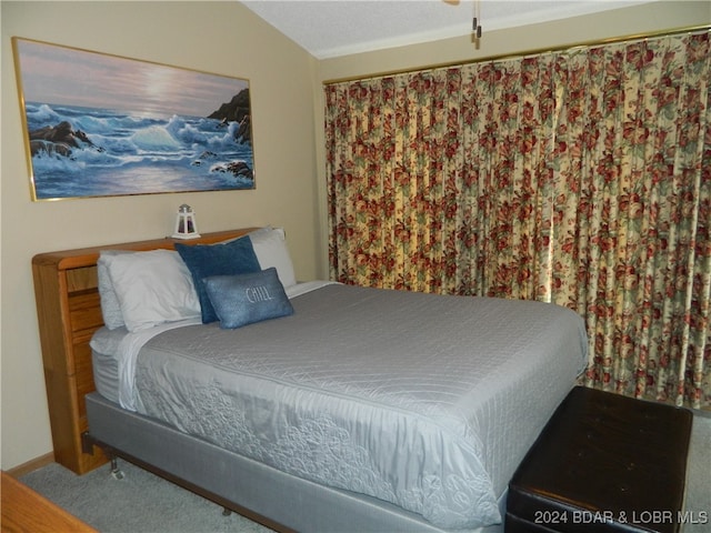 carpeted bedroom featuring vaulted ceiling