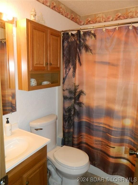 bathroom featuring a shower with shower curtain, toilet, and vanity