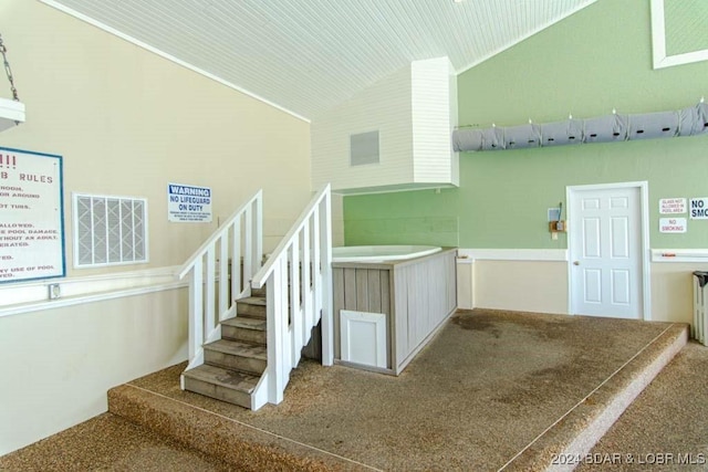 stairs with vaulted ceiling and carpet floors