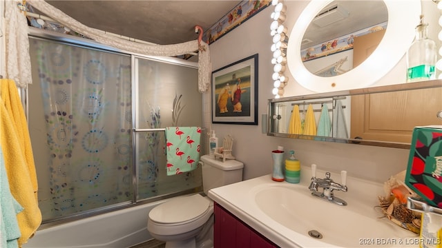 full bathroom with vanity, enclosed tub / shower combo, and toilet