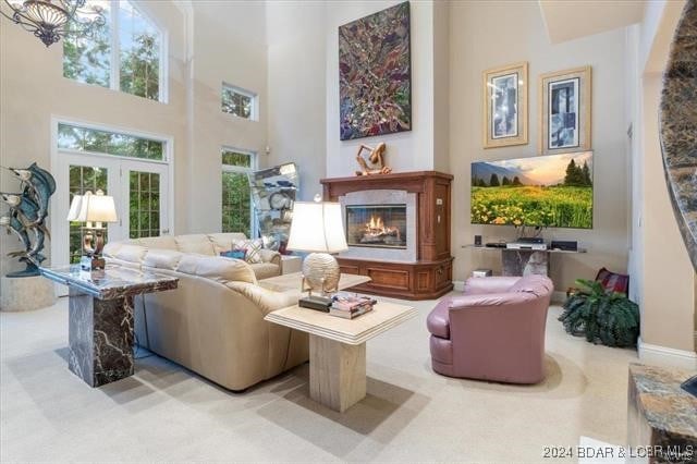 living room with carpet and a towering ceiling