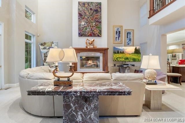 living room with a towering ceiling and light carpet