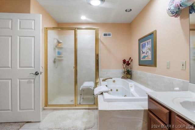 bathroom with shower with separate bathtub, vanity, and tile patterned floors