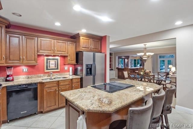 kitchen featuring sink, a kitchen island, light tile patterned floors, and black appliances