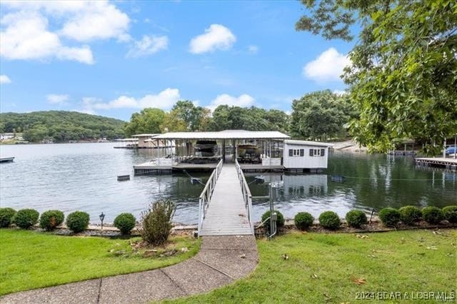 dock area with a water view and a yard