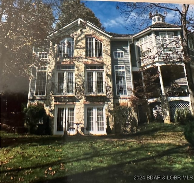 view of front of home with a front yard and french doors