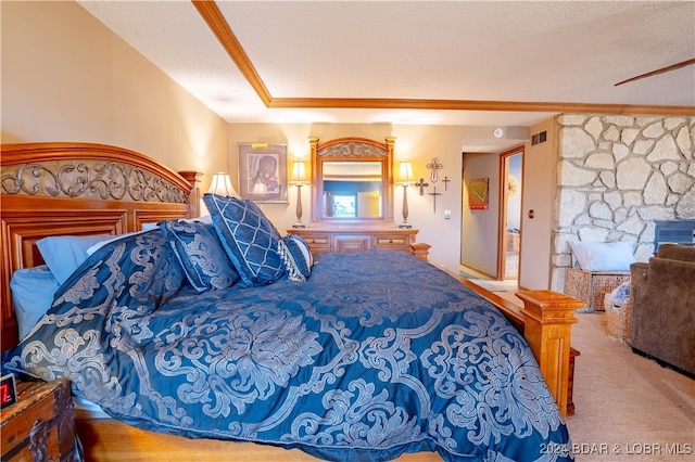 bedroom with a textured ceiling, a fireplace, carpet flooring, and visible vents