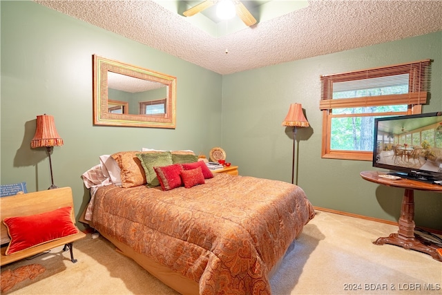 carpeted bedroom featuring a ceiling fan, a textured ceiling, and baseboards