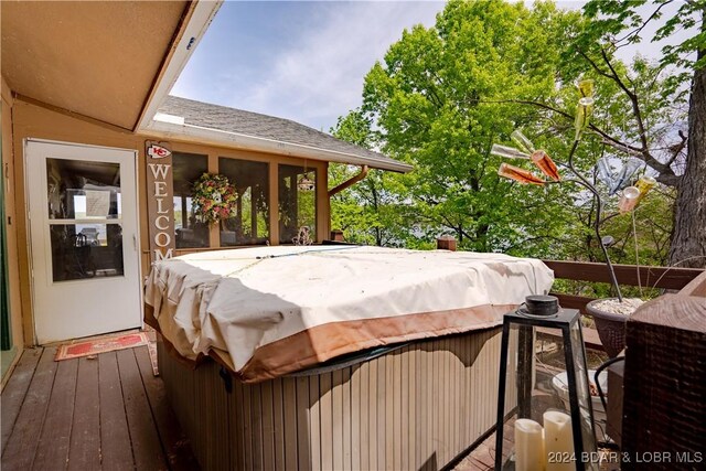 exterior space with a wooden deck and a hot tub