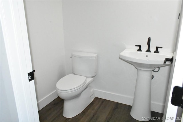 bathroom with toilet and wood-type flooring