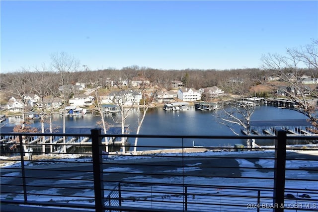 dock area with a water view and a balcony