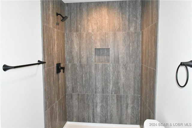 bathroom featuring toilet and a tile shower