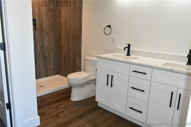 bathroom with hardwood / wood-style flooring, toilet, vanity, and walk in shower