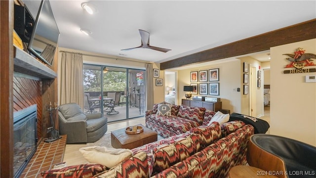 living room featuring a glass covered fireplace and ceiling fan