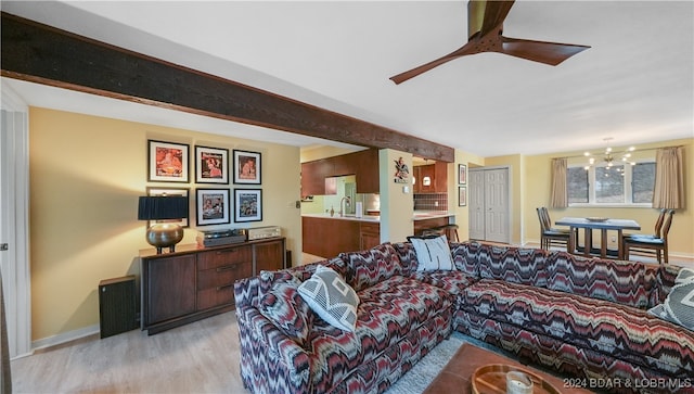 living room with ceiling fan with notable chandelier and light hardwood / wood-style flooring