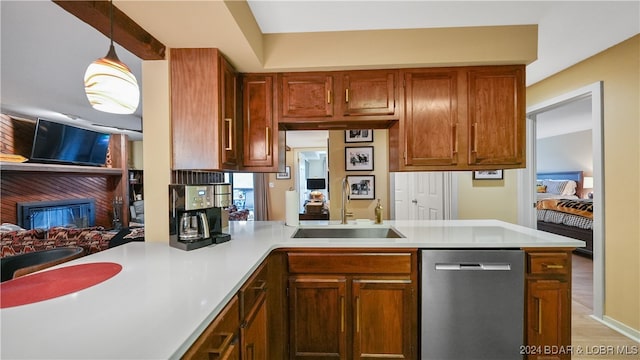 kitchen with sink, decorative light fixtures, kitchen peninsula, dishwasher, and light hardwood / wood-style floors