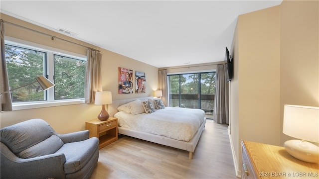 bedroom featuring multiple windows and light hardwood / wood-style floors