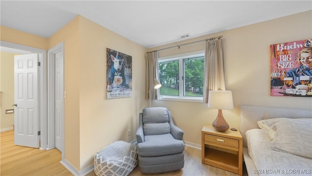 sitting room featuring baseboards, visible vents, and wood finished floors