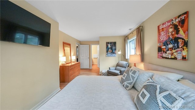 bedroom with wood finished floors and baseboards