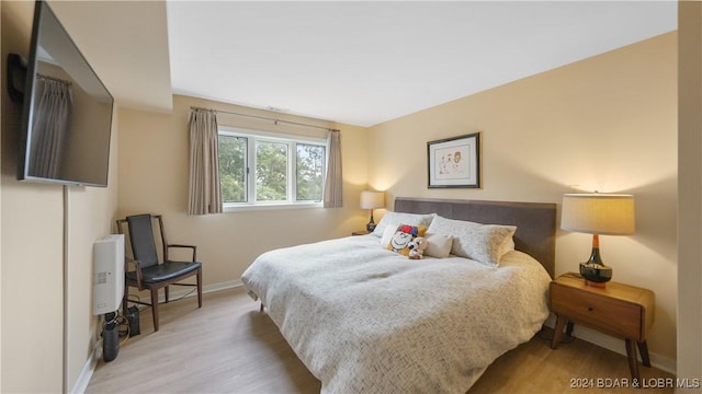 bedroom with baseboards and wood finished floors