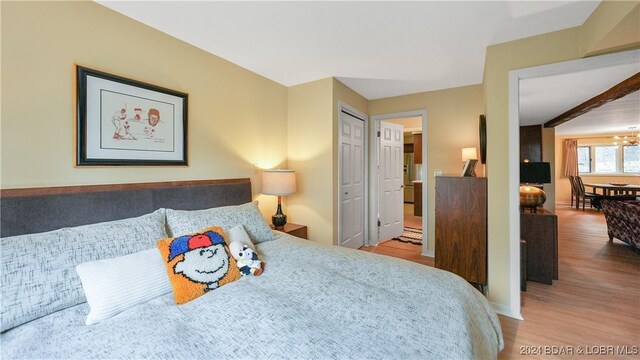 bedroom with wood-type flooring and a chandelier