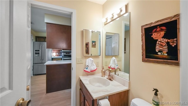 bathroom with vanity, toilet, and wood finished floors